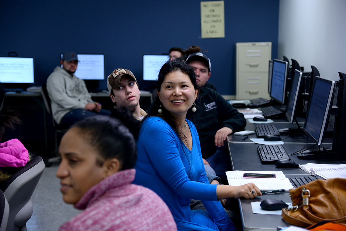 Students in class with computers, smiling students