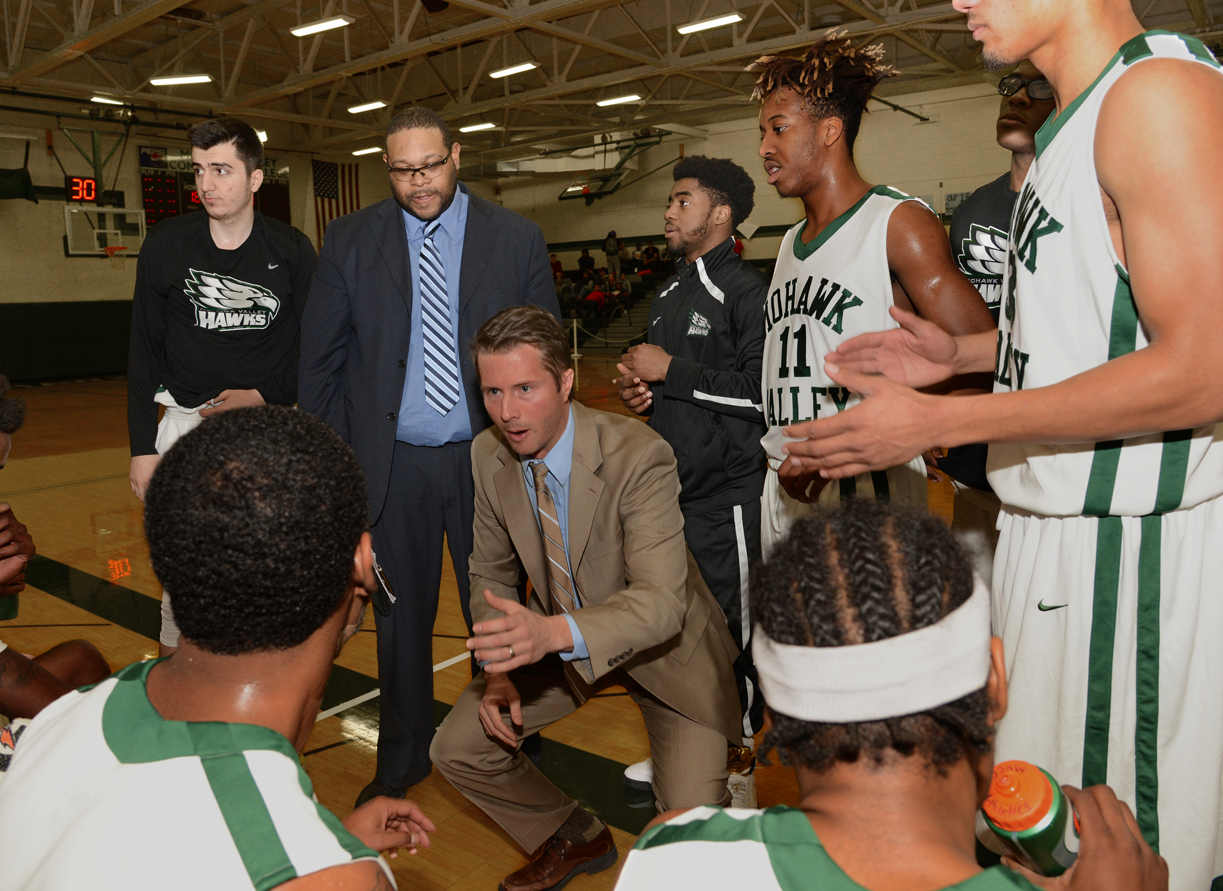 Basketball coach talking to players during game