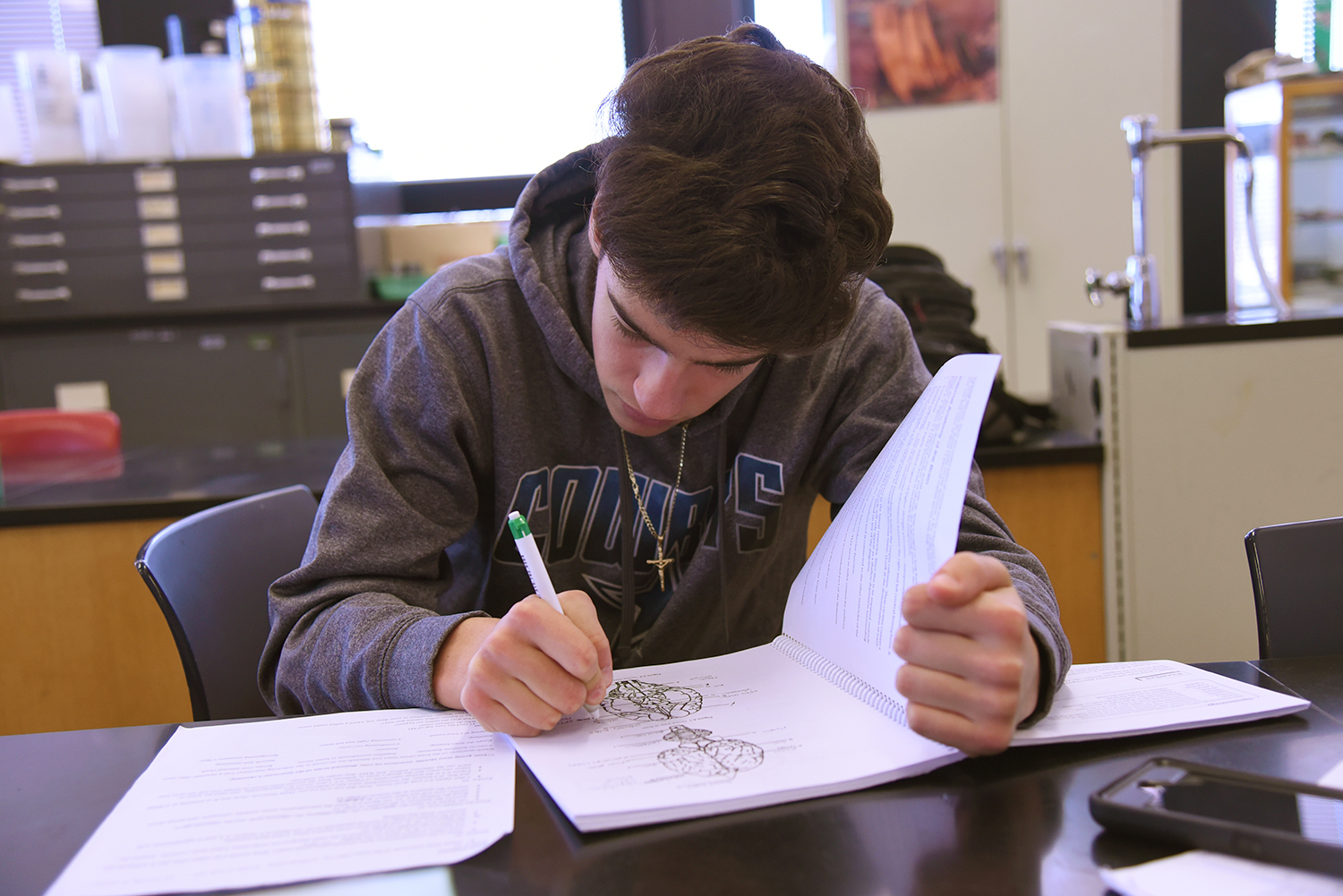 Student reading book in classroom