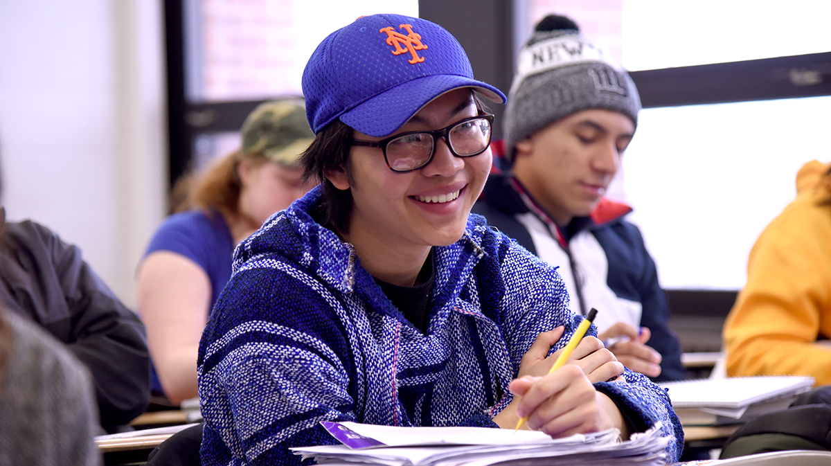 Student smiling, sitting in classroom