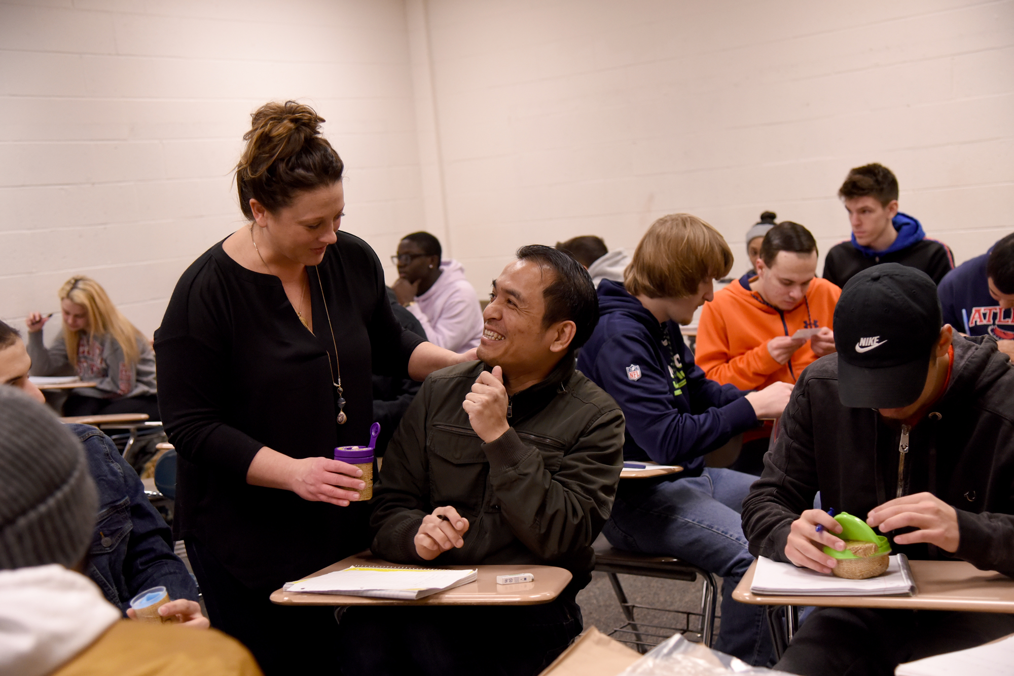 Professor and student talking, smiling in classroom