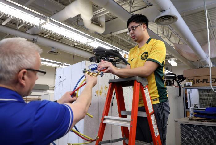 Instructor Stover with student faculty member working with student in airconditioning lab