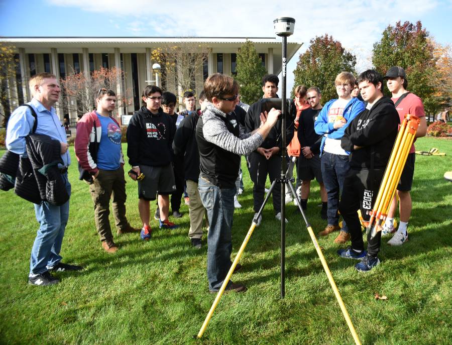 faculty member and students working with machinery in the Utica campus quad