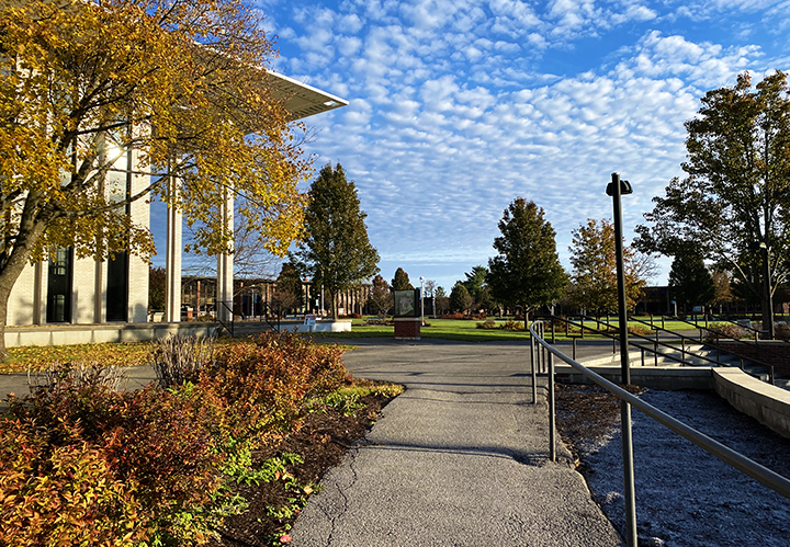 MVCC campus during fall, blue sky with clouds in the background with brown, orange, and yellow leaves on trees