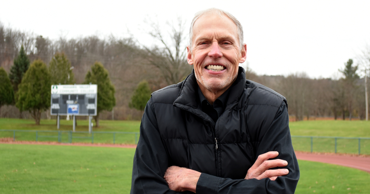 Coach Bob Gould standing outside on the MVCC running track