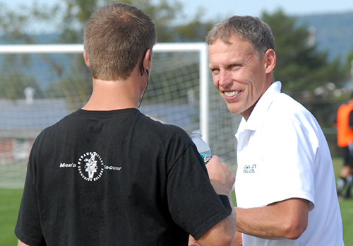 Coach smiling, talking to soccer player