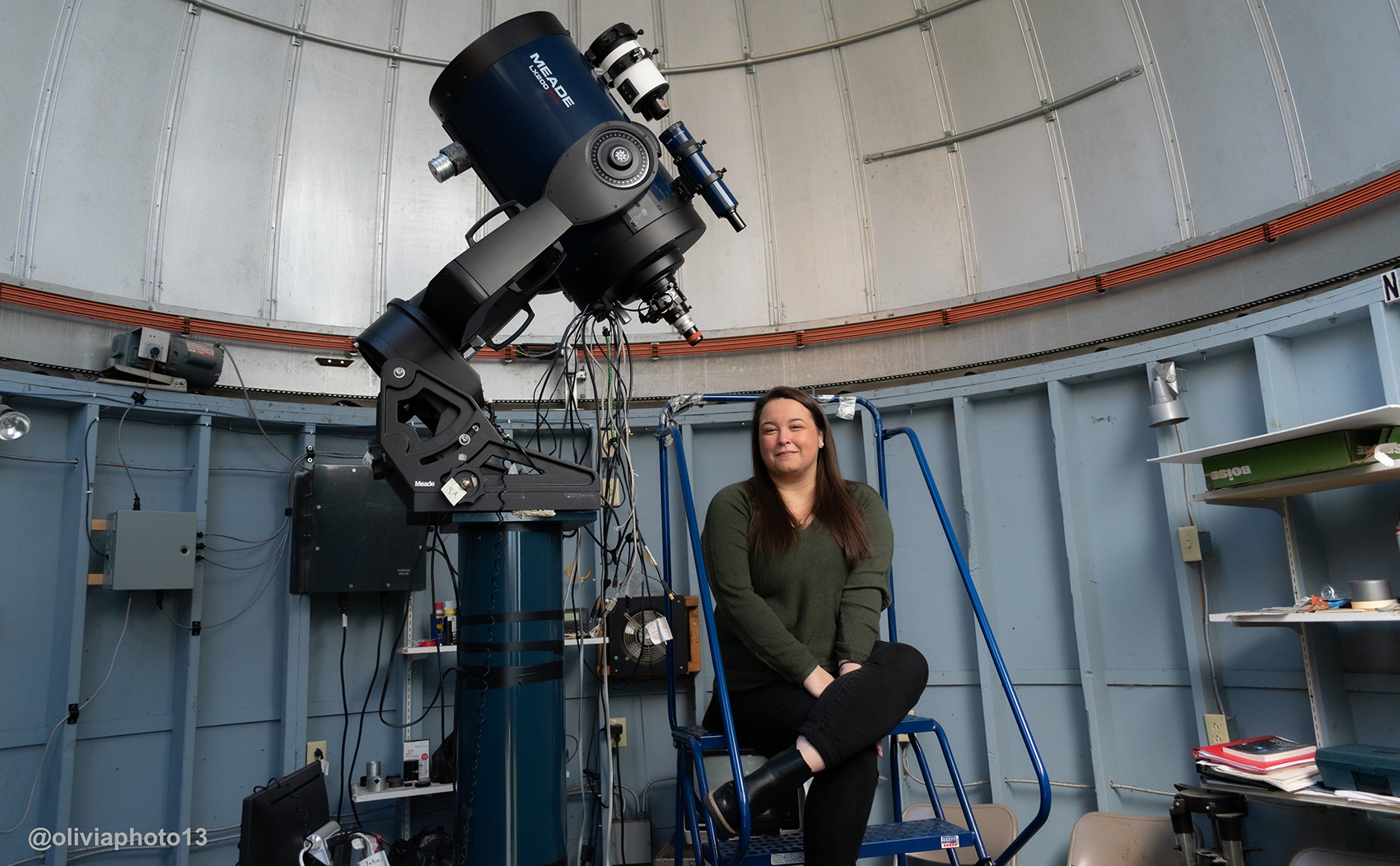 Image of MVCC alumna Brittany Vanderhoof sitting with telescope at RIT