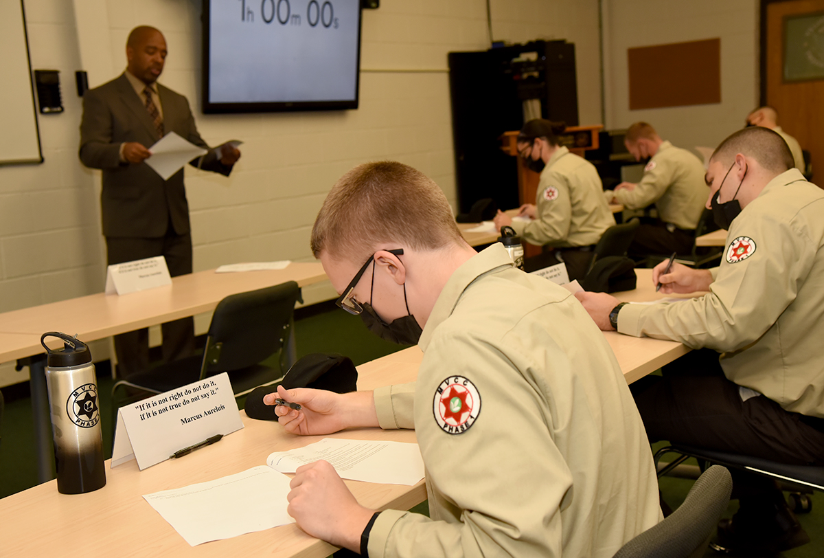 Student cadets in uniforms working in class with instructor in front of class