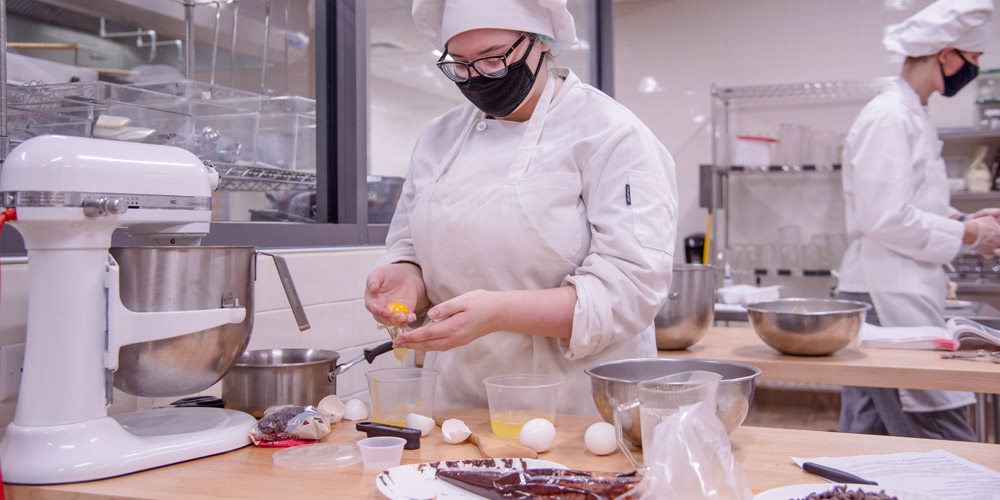 student preparing ingradients for a baking project in a state of the art kitchen