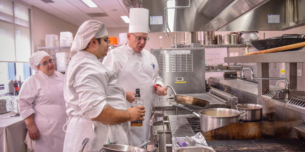 Students practice cooking in a state of the art kitchen in rome campus