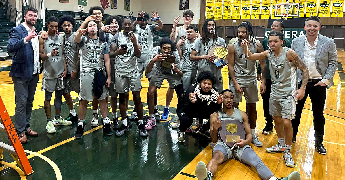 Men's Basketball Team posing with award plaque in celebratory fashion