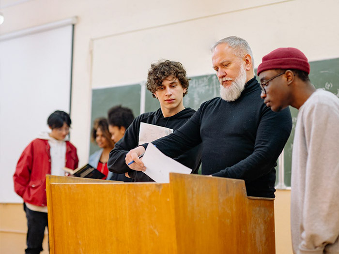 image of students gathered around teacher's podium