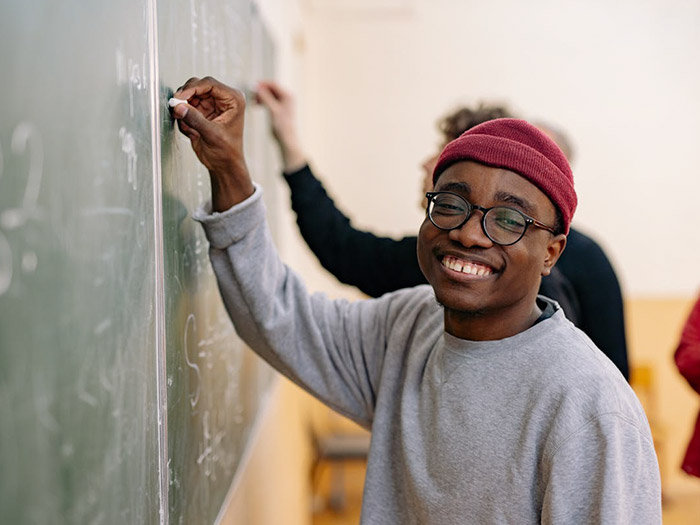 smiling student at chalkboard