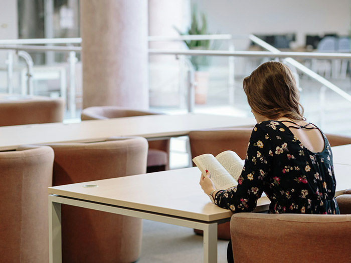 back of student reading while sitting at a table