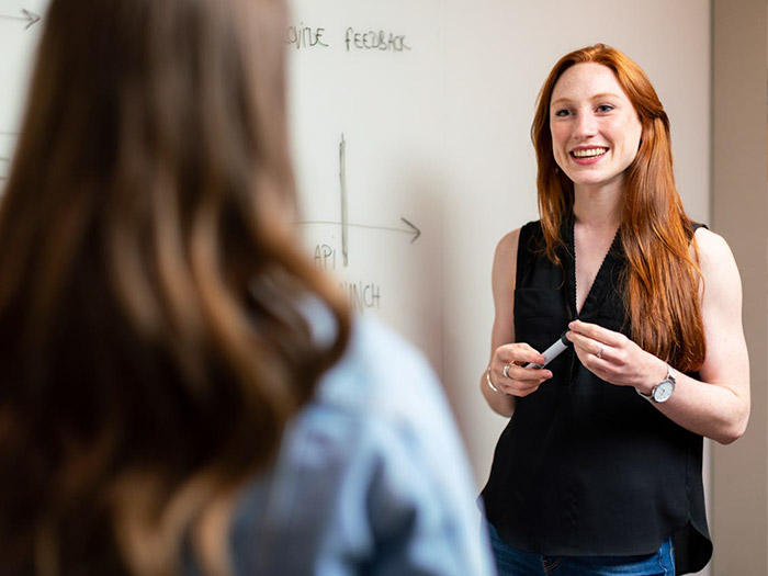 teacher in front of whiteboard smiling