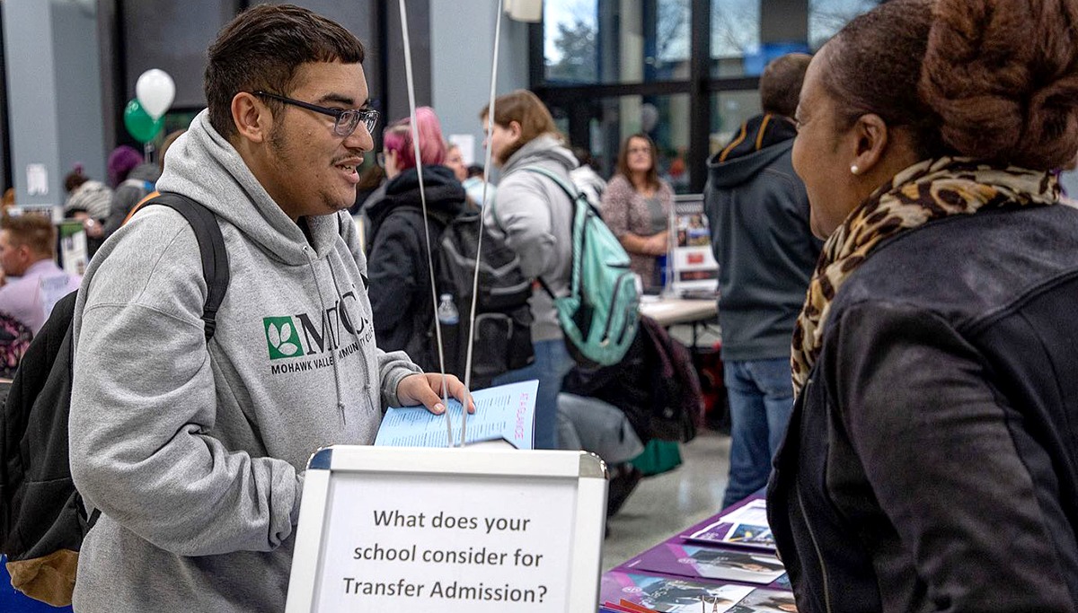 Student talking to college representative at transfer fair